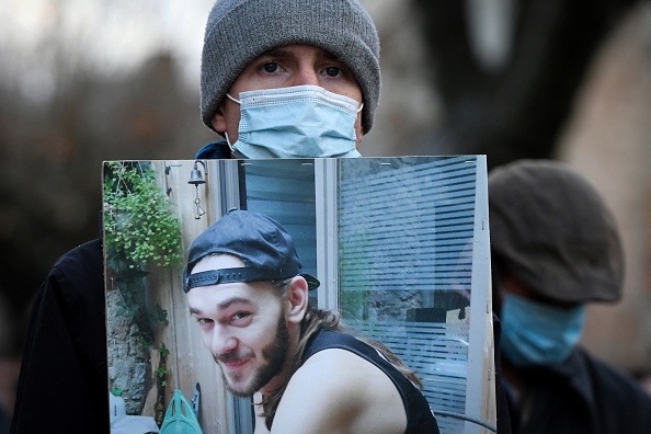 Un ami tient un portrait de Morgan Keane en tête d'une marche blanche en hommage au jeune homme, le 4 décembre 2021. (Photo: VALENTINE CHAPUIS/AFP via Getty Images)