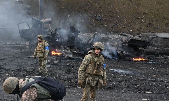 Des soldats ukrainiens cherchent et ramassent des obus non explosés après un combat avec un groupe d'assaillants russes dans la capitale ukrainienne de Kiev, le 26 février 2022. (Photo : SERGEI SUPINSKY/AFP via Getty Images)