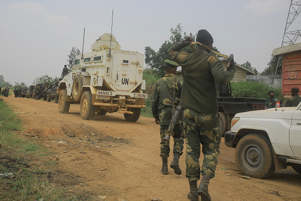 Des soldats des FARDC et des casques bleus escortent des  véhicules civils sur l'axe routier Beni-Komanda près de Walese Vonkutu qui est le théâtre d'attaques et d'embuscades meurtrières de la part des rebelles ADF dans l'est de la République démocratique du Congo. (Photo :  SEBASTIEN KITSA MUSAYI/AFP via Getty Images)