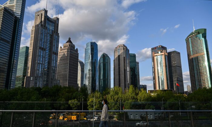 Une femme marche dans le quartier financier de Lujiazui à Shanghai, en Chine, le 17 octobre 2022. (Hector Retamal/AFP via Getty Images)
