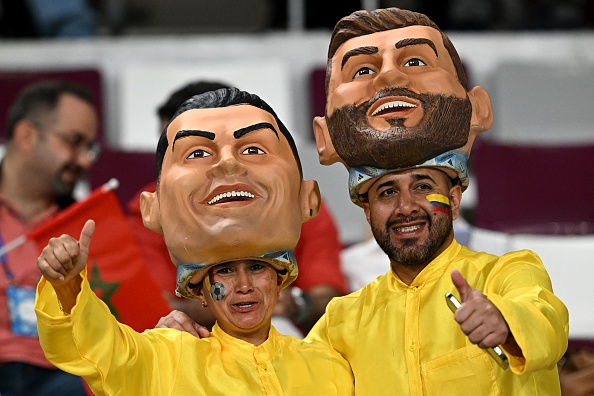 Des fans de football portant des masques de l'attaquant portugais Cristiano Ronaldo et de l'attaquant argentin Lionel Messi. (Photo : PAUL ELLIS/AFP via Getty Images)