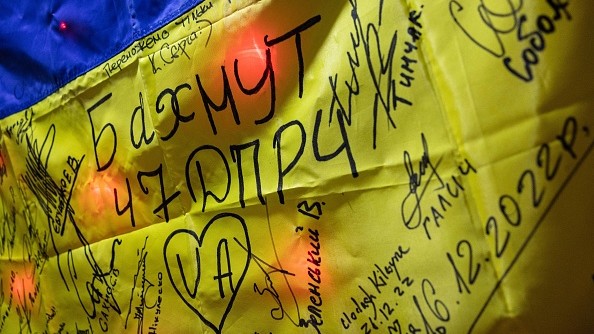 Cette photo prise le 31 décembre 2022 montre un drapeau ukrainien couvert de signatures de pompiers et de fonctionnaires, à la caserne de la ville de Bakhmut, dans l'est de l'Ukraine. (Photo par SAMEER AL-DOUMY/AFP via Getty Images)