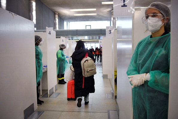 Un voyageur d'un vol en provenance de Chine traverse les cabines de test COVID-19 à l'aéroport Paris- CDG de Roissy, le 1er janvier 2023, alors que la France renforce les mesures sanitaires aux frontières pour les passagers en provenance de Chine. (Photo : JULIEN DE ROSA/AFP via Getty Images)