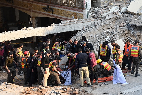 Des secouristes transportent les restes des victimes de l'explosion dans les décombres d'une mosquée à Peshawar, le 30 janvier 2023. (Photo : ABDUL MAJEED/AFP via Getty Images)