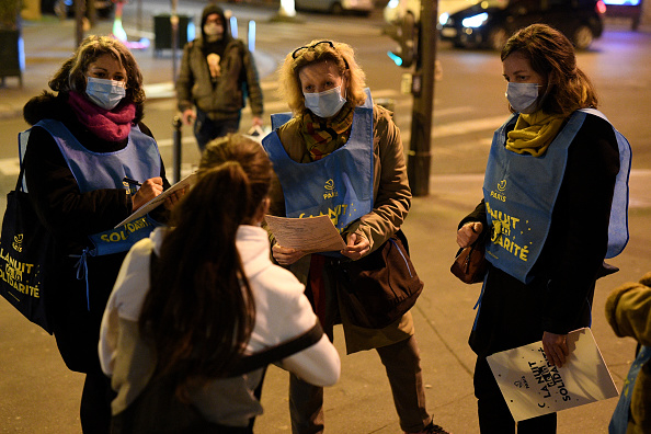 Un groupe de bénévoles discute avec une femme sans-abri lors de la 4e nuit annuelle de la Solidarité à Paris. (Photo : Pascal Le Segretain/Getty Images)