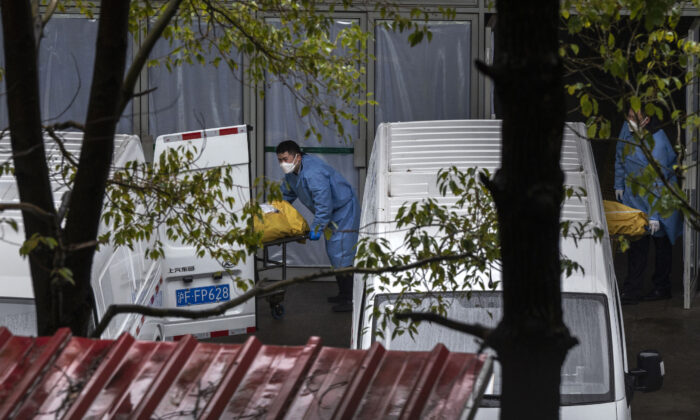 Chargement des corps pour les emmener à la crémation dans un salon funéraire local très fréquenté à Shanghai, le 13 janvier 2023. (Kevin Frayer/Getty Images)