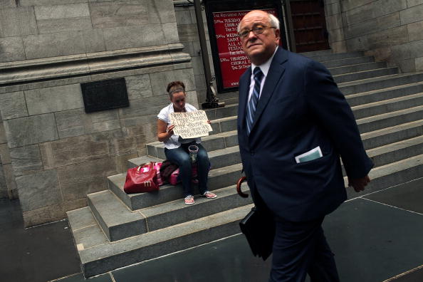 Image d'illustration - Un homme d'affaires passe devant une femme sans-abri. (Spencer Platt/Getty Images)