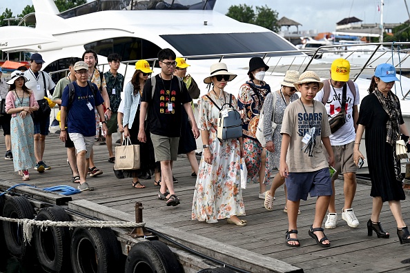 Des touristes chinois à l'île de Serangan à l'île de Lombok à Denpasar, sur l'île balnéaire indonésienne de Bali. (Photo : SONNY TUMBELAKA/AFP via Getty Images)