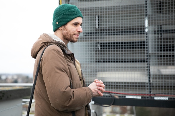 Yanis Maacha, cofondateur et directeur technique de WIND my ROOF, regarde une éolienne de toit, appelée "WindBox", installée sur le toit d'un immeuble résidentiel à Rouen, le 2 février 2023. (Photo : LOU BENOIST/AFP via Getty Images)