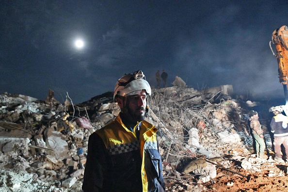 Un membre de la défense civile syrienne, connue sous le nom de Casques blancs, se tient près des décombres d'un bâtiment effondré à Jindayris. (RAMI AL SAYED/AFP via Getty Images)