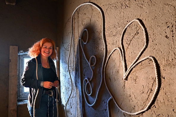 Un bénévole présente une décoration murale à l'intérieur d'une maison en torchis à Acs, Hongrie. (ATTILA KISBENEDEK/AFP via Getty Images)