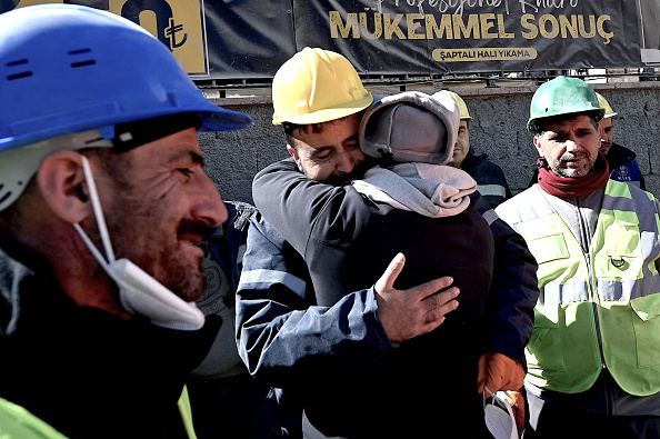 L'oncle d'Aleyna Olmez (au centre), après que la jeune femme de 17 ans a été extirpée d'un bâtiment effondré, 248 heures après le séisme de magnitude 7,8. (OZAN KOSE/AFP via Getty Images)