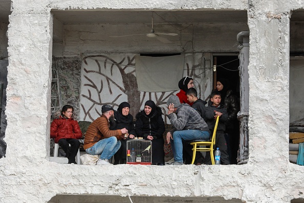 Ali al-Bash et sa mère Amina Raslan boivent du café chez eux, dans un bâtiment endommagé du quartier al-Masharqa de la ville d'Alep, Syrie. (LOUAI BESHARA/AFP via Getty Images)