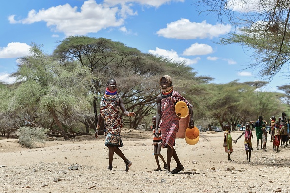 Des femmes et des enfants portent des jerrycans alors qu'ils cherchent de l'eau dans des puits peu profonds creusés dans le lit d'une rivière à Sopel, Kenya. (TONY KARUMBA/AFP via Getty Images)