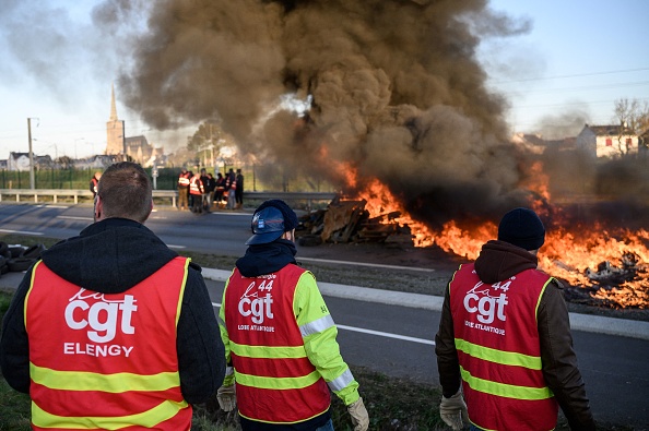 Des syndicalistes bloquent une route avec un feu devant la raffinerie Total Energies lors d'une action appelée par la CGT contre la réforme des retraites. (LOIC VENANCE/AFP via Getty Images)