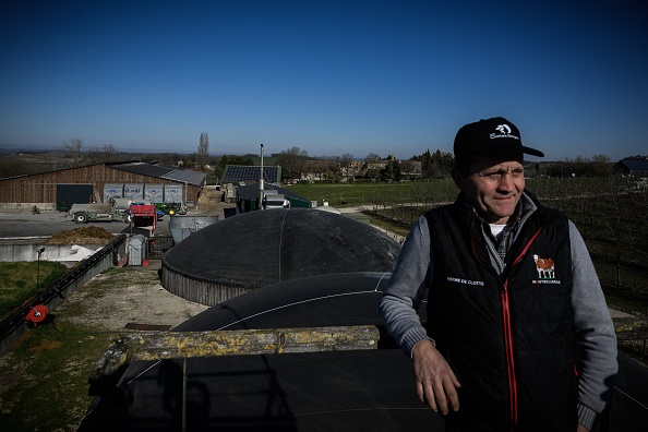 Bertrand Guerin se tient près d'unités de biométhane sur la ferme de la famille Guerin, qui produit du biométhane, également connu sous le nom de gaz naturel renouvelable, à Beaumontois-en-Périgord. (PHILIPPE LOPEZ/AFP via Getty Images)