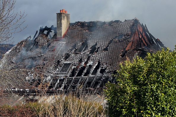 La fumée s'échappe du toit d'une maison d'habitation qui a pris feu après une forte explosion à Yverdon-les-Bains, en Suisse, où "plusieurs corps" ont été retrouvés. (OLIVIER ALLENSPACH/FLASHPRESS/ALLENSPACH/AFP via Getty Images)