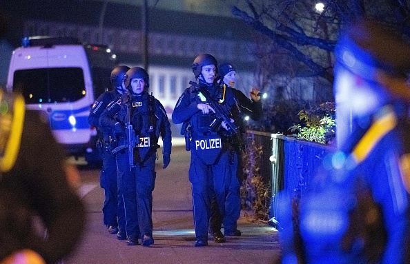 Des policiers lourdement armés inspectent la zone près d'une église des Témoins de Jéhovah lors d'une fusillade à Hambourg, en Allemagne, le 9 mars 2023. (DANIEL REINHARDT/AFP via Getty Images)