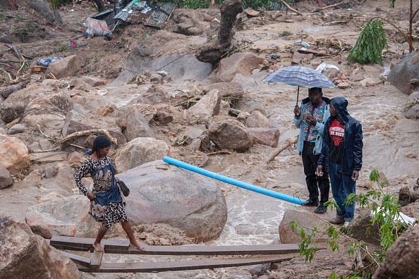 Une personne traverse un "pont" au-dessus des eaux de crue à Blantyre le 14 mars 2023, en raison des fortes pluies qui ont suivi l'arrivée du cyclone Freddy. (AMOS GUMULIRA/AFP via Getty Images)