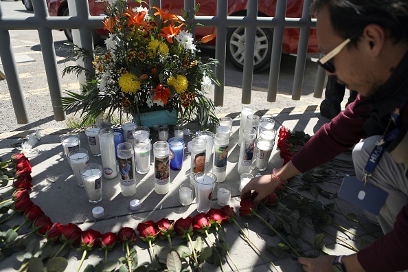 Un militant dépose une offrande florale sur un autel de fortune devant un centre de détention pour immigrés à Ciudad Juarez, dans l'État de Chihuahua, au Mexique. (HERIKA MARTINEZ/AFP via Getty Images)