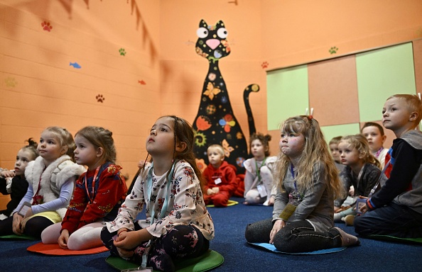 Des enfants jouent dans un abri antiaérien dans la cave d'un jardin d'enfants à Kiev pendant l'invasion russe de l'Ukraine. (GENYA SAVILOV/AFP via Getty Images)