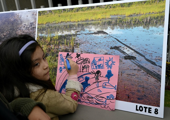 Une petite fille participe à une manifestation de militants devant la compagnie pétrolière péruvienne PetroPeru à Lima, le 21 septembre 2017, pour soutenir les tribus amazoniennes Achuar, Kichwa et Quechua affectées par les activités de l'industrie pétrolière sur leurs terres ancestrales. (Photo CRIS BOURONCLE/AFP via Getty Images)