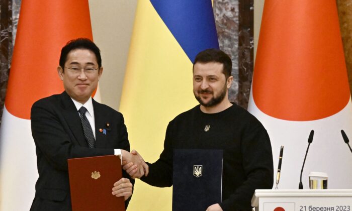 Le président ukrainien Volodymyr Zelensky et le Premier ministre japonais Fumio Kishida se serrent la main après la signature de documents bilatéraux avant la conférence de presse à l'issue de leur rencontre à Kiev, en Ukraine, le 21 mars 2023. (Genya Savilov/AFP via Getty Images)