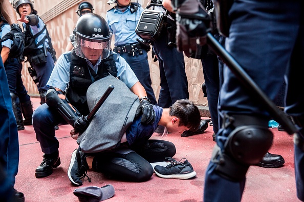 La police détient un homme à l'intérieur d'un centre commercial entre des partisans de la liberté et des manifestants anti-gouvernementaux dans le quartier de Kowloon Bay à Hong Kong, en 2019. Illustration. (ISAAC LAWRENCE/AFP via Getty Images)