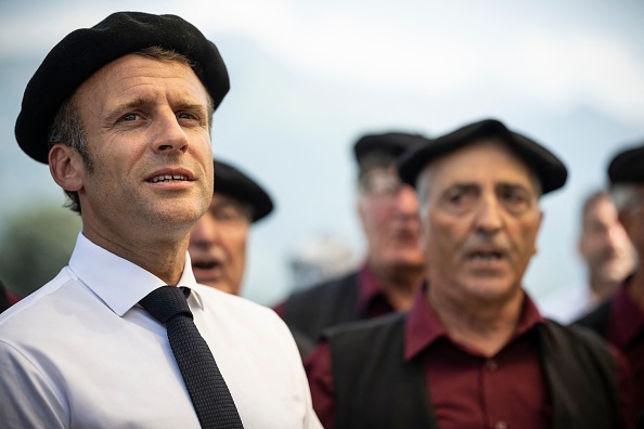 Le président Emmanuel Macron chante lors d'une visite axée sur le pastoralisme à Argeles-Gazost, le 21 juillet 2022. (LIONEL BONAVENTURE/POOL/AFP via Getty Images)