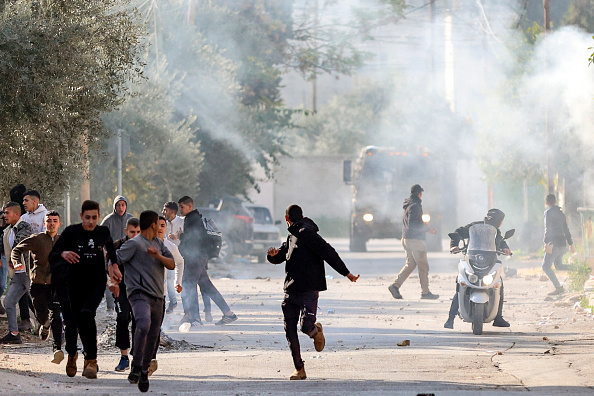 Des Palestiniens se mettent à l'abri lors d'affrontements avec les forces israéliennes dans la ville de Jénine, en Cisjordanie occupée. Illustration. (ZAIN JAAFAR/AFP via Getty Images)