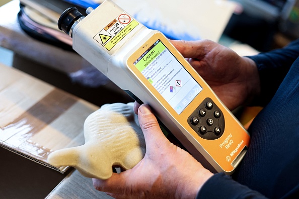 Un douanier belge utilise un scanner "Raman" pour contrôler ce qui semble être un lapin en chocolat à l'aéroport de Bruxelles à Zaventem, le 6 avril 2023.   (KENZO TRIBOUILLARD/AFP via Getty Images)