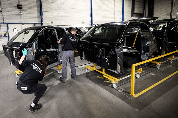 Des employés travaillent sur la ligne de production de voitures électriques sans permis à l'usine du groupe Ligier à Bouffere. (LOIC VENANCE/AFP via Getty Images)