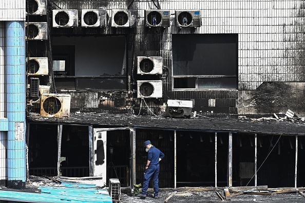 Un enquêteur inspecte les dégâts à l'hôpital Changfeng à Pékin le 19 avril 2023, après l'incendie qui s'est déclaré un jour plus tôt. (GREG BAKER/AFP via Getty Images)