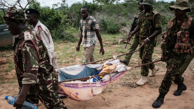 Des agents de sécurité transportent un jeune secouru dans la forêt de Shakahola, à l'extérieur de la ville côtière de Malindi, le 23 avril 2023. (YASUYOSHI CHIBA/AFP via Getty Images)