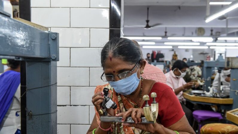 Une ouvrière examine des pierres de diamant à Rijiya Gems en Inde, dans un atelier de taille et de polissage. (Photo SAM PANTHAKY/AFP via Getty Images)