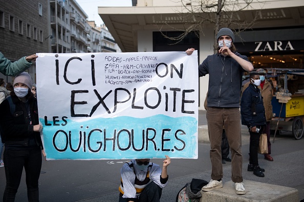 Des manifestants tiennent une banderole de soutien aux minorités ouïghours. (LOIC VENANCE/AFP via Getty Images)