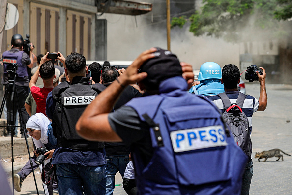 Des journalistes réagissent lors d'un bombardement aérien israélien dans la ville de Gaza, le 6 août 2022. (MOHAMMED ABED/AFP via Getty Images)