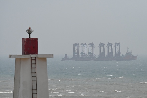 Un navire navigue dans le détroit de Taïwan, devant un phare sur l'île de Pingtan, le 8 avril 2023. (GREG BAKER/AFP via Getty Images)