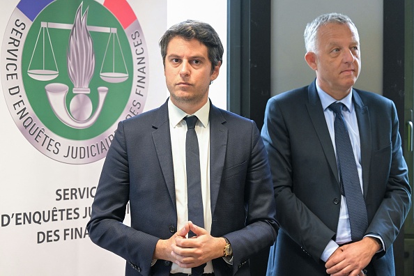 Le ministre délégué aux Comptes publics Gabriel Attal (au c.) et le directeur du SEJF Christophe Perruaux lors d'une visite au service d'enquêtes judiciaires des finances (SEJF) à Ivry-sur-Seine, le 9 mai 2023. (BERTRAND GUAY/AFP via Getty Images)