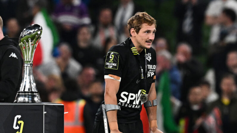 Le demi de mêlée français de Toulon Baptiste Serin avec ses béquilles, se prépare à célébrer la victoire avec ses coéquipiers, après avoir remporté le match de la finale de l'European Challenge Cup entre les Glasgow Warriors (SCO) et le Rugby Club Toulonnais (FRA) à l'Aviva Stadium à Dublin le 19 mai 2023. (Photo PAUL ELLIS/AFP via Getty Images)