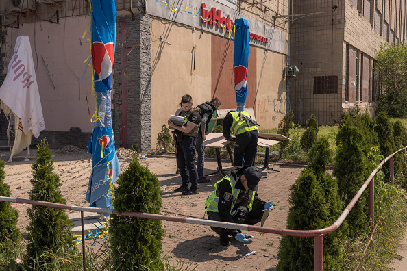 Des officiers de police travaillent sur le site où un bâtiment a été endommagé lors d'une attaque de drone russe le 28 mai 2023 à Kiev, en Ukraine. (Roman Pilipey/Getty Images)