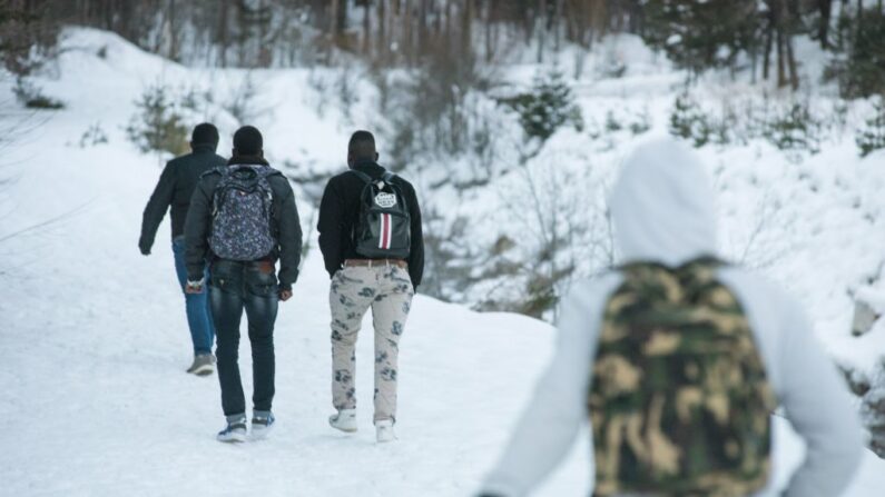 Des migrants marchent  dans un Col enneigé pour franchir la frontière entre la France et l'Italie. (Photo PIERO CRUCIATTI/AFP via Getty Images)