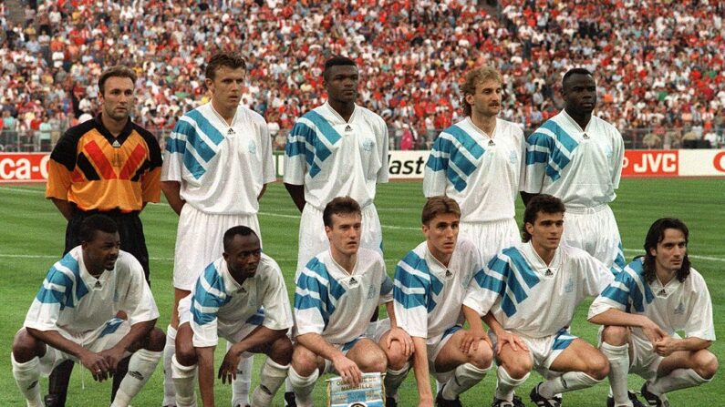 L'équipe de football de l'Olympique de Marseille avant la finale de la Coupe d'Europe des clubs champions contre le Milan AC, le 26 mai 1993 à Munich. (Debout, de G à D : Fabien Barthez, Frank Sauzée, Marcel Desailly, Rudi Voeller, Basile Boli; 1er rang, de G à D : Jocelyn Angloma, Abedi Pelé, Didier Deschamps, Alan Boksic, Jean-Jacques Eydelie, Eric Di Meco).  (GEORGES GOBET/AFP via Getty Images)