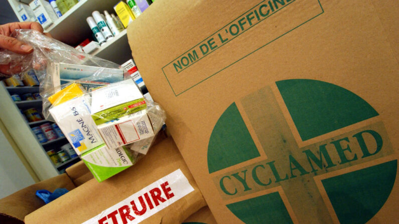 Un pharmacien remplit un carton réservé à la récupération des médicaments usagés, non-utilisés ou périmés, rapportés par les clients dans le cadre de l'opération Cyclamed. (Photo MYCHELE DANIAU/AFP via Getty Images)