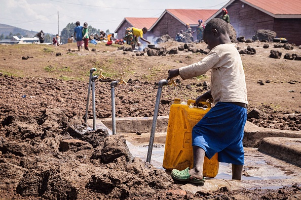 Un enfant réfugié de la République démocratique du Congo (RDC) cherche de l'eau dans la zone d'attente de Nyakabande à Kisoro, en Ouganda. (BADRU KATUMBA/AFP via Getty Images)