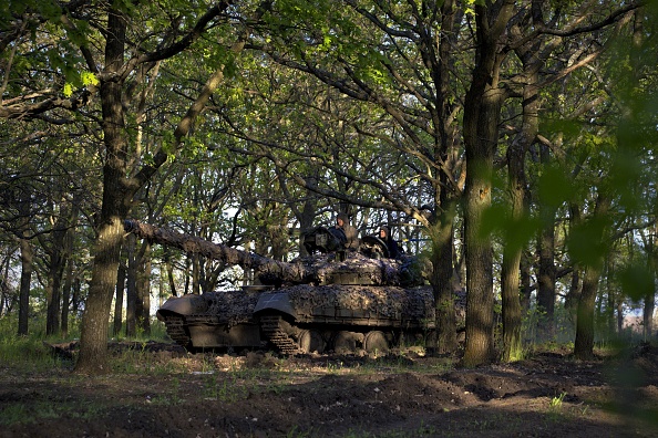 Des militaires ukrainiens du groupe tactique Adam sortent un char T-64 d'une ligne de front près de la ville de Bakhmut, dans la région de Donetsk, le 7 mai 2023. (SERGEY SHESTAK/AFP via Getty Images)