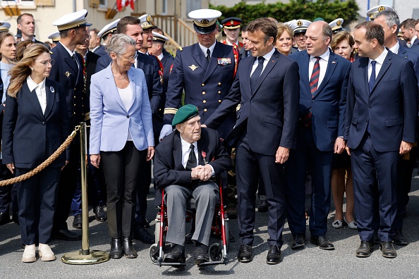 Patricia Miralles, Secrétaire d'État aux Anciens Combattants et à la Mémoire, Élisabeth Borne, Première ministre, Léon Gautier, vétéran du Commando Kieffer de la Seconde Guerre mondiale, et Emmanuel Macron, Président de la République française. (LUDOVIC MARIN/POOL/AFP via Getty Images)