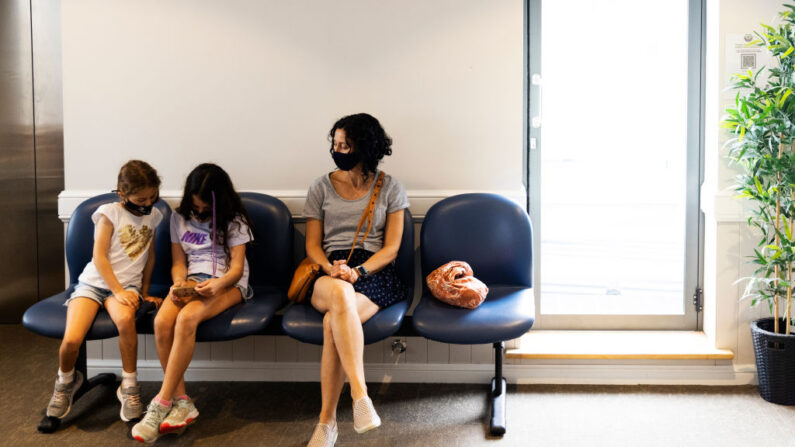 Maria Persic est assise avec ses filles Millie Persic (à gauche) et Sofia Persic pendant une période d'observation après l'administration du vaccin COVID-19 de Pfizer au Sydney Road Family Medical Practice à Balgowlah, Sydney, Australie, le 11 janvier 2022. (Jenny Evans/Getty Images)