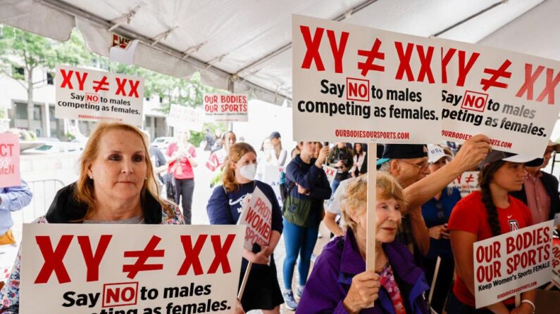 Des manifestants prêtent l'oreille au programme des interventions à l'occasion d'un rassemblement "Our Bodies, Our Sports" pour le 50e anniversaire du Titre IX sur la Freedom Plaza dans le District de Columbia, le 23 juin 2022. Organisée par de nombreux groupes de femmes sportives, la manifestation invitait le président Joe Biden à imposer des restrictions aux femmes transgenres et à "plaider pour que les sports féminins restent féminins". (Anna Moneymaker/Getty Images)