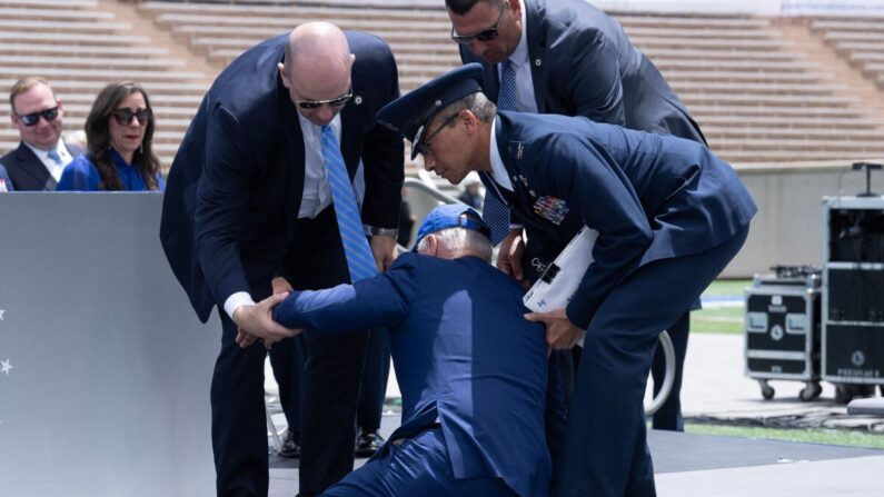 Joe Biden est aidé à se relever après être tombé lors de la cérémonie de remise des diplômes à l'Académie de l'armée de l'air américaine, près de Colorado Springs, le 1er juin 2023. (Brendan Smialowski/AFP via Getty Images)